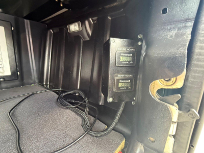 Truck interior side panel showing two Honeywell hour meters and wiring in the cab of a Freightliner Cascadia 126.