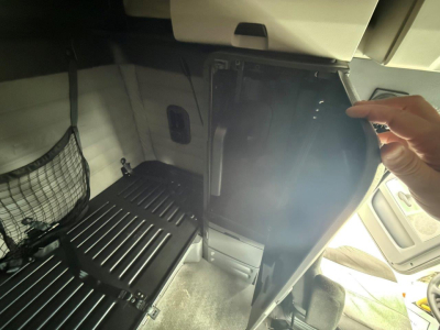 Freightliner Cascadia 126 truck interior sleeper area with storage drawers and partition; cabin view including seating area and overhead console.