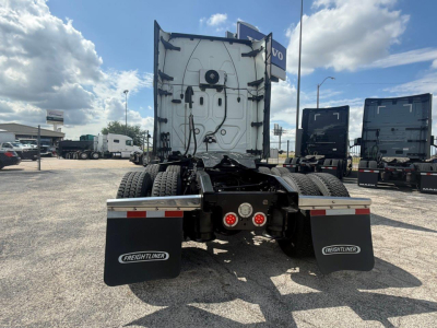 Truck chassis rear view of a 2021 Freightliner Cascadia 126, showing the fifth wheel area, twin rear axles, and mud flaps with Freightliner branding.