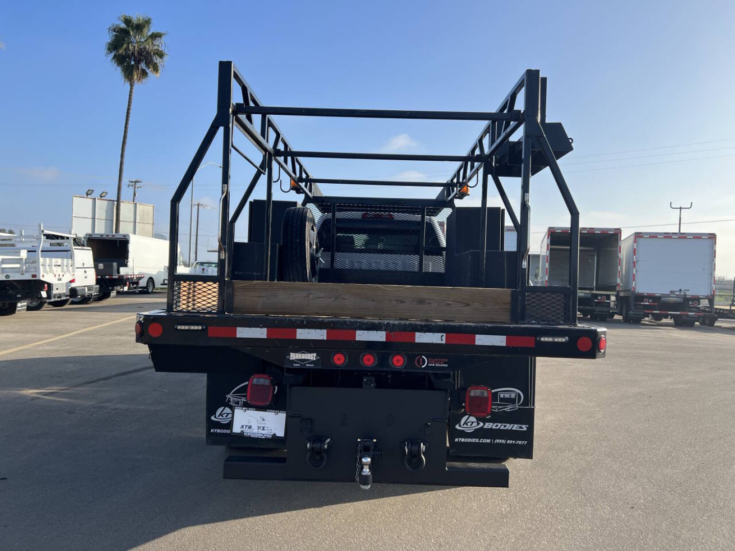 Truck bed with open framework on a Silverado flatbed truck showing rear with lights and hitch