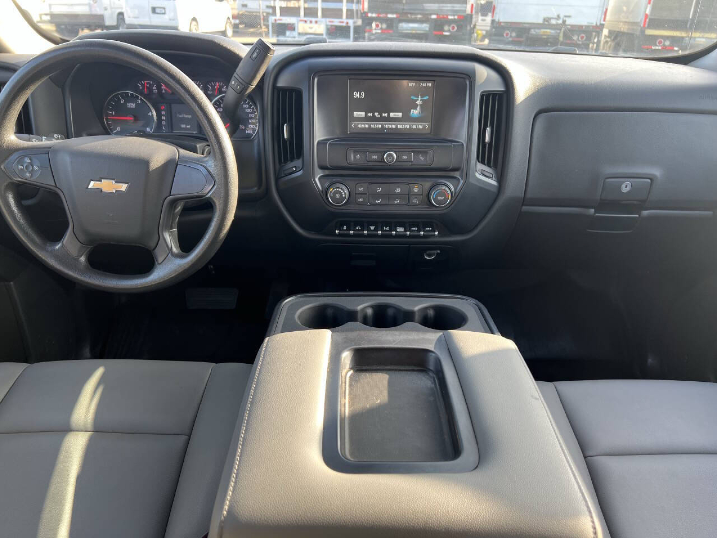 Chevrolet Silverado interior front cabin with steering wheel, central touchscreen, and cup holders; dashboard and control buttons visible.