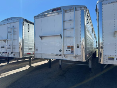 Timpte Super Hopper trailer showing rear access ladder and reflective metal panels.