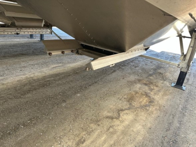 Timpte Super Hopper trailer undercarriage showing bottom fold-out step/ladder and hydraulic or support beam with metallic finish.