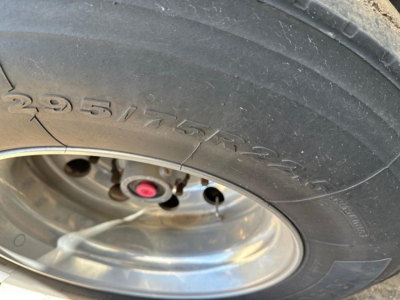 Tire and wheel showing the sidewall with markings 295/75R22.5 and a chrome wheel hub. 