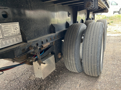 Trailer wheel assembly and undercarriage of a 2019 Manac extendable flatbed showing dual rear tires and underbody components.