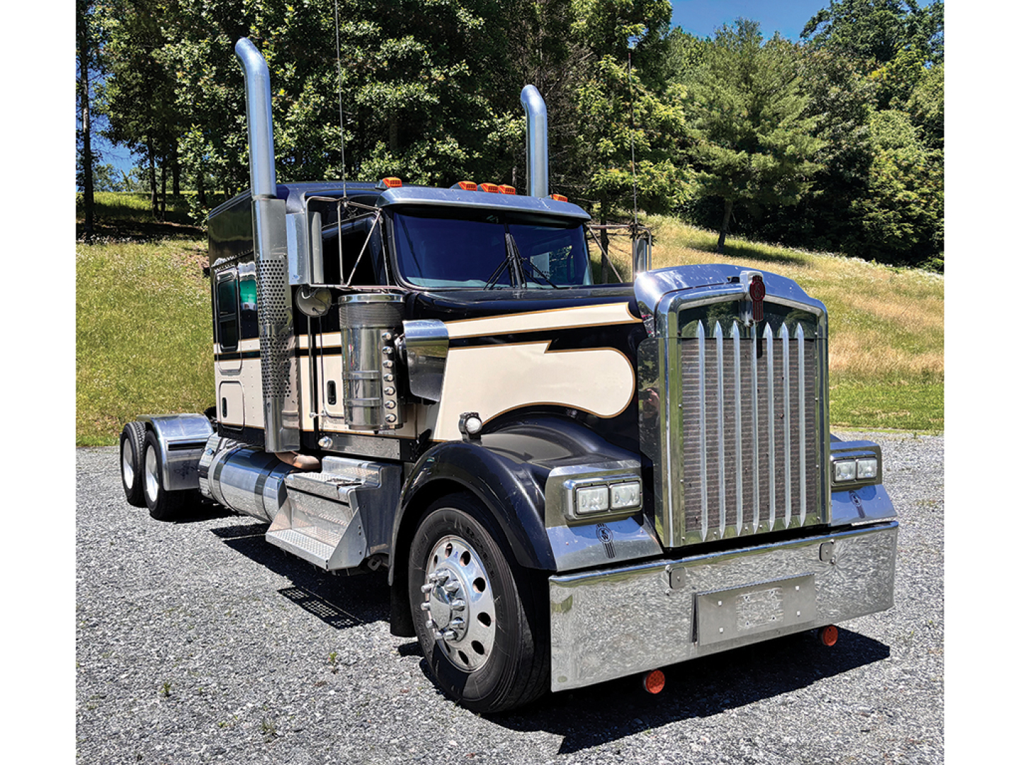 Kenworth W-900 AeroCab conventional sleeper truck in service view with chrome bumper and stacked exhaust stacks.