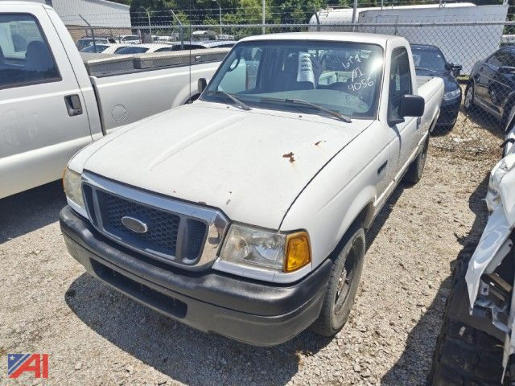 Ford Ranger pickup truck in a lot, white, 2005 model, front and passenger side visible with rust spots on hood and grille, two-door cab, daytime lighting