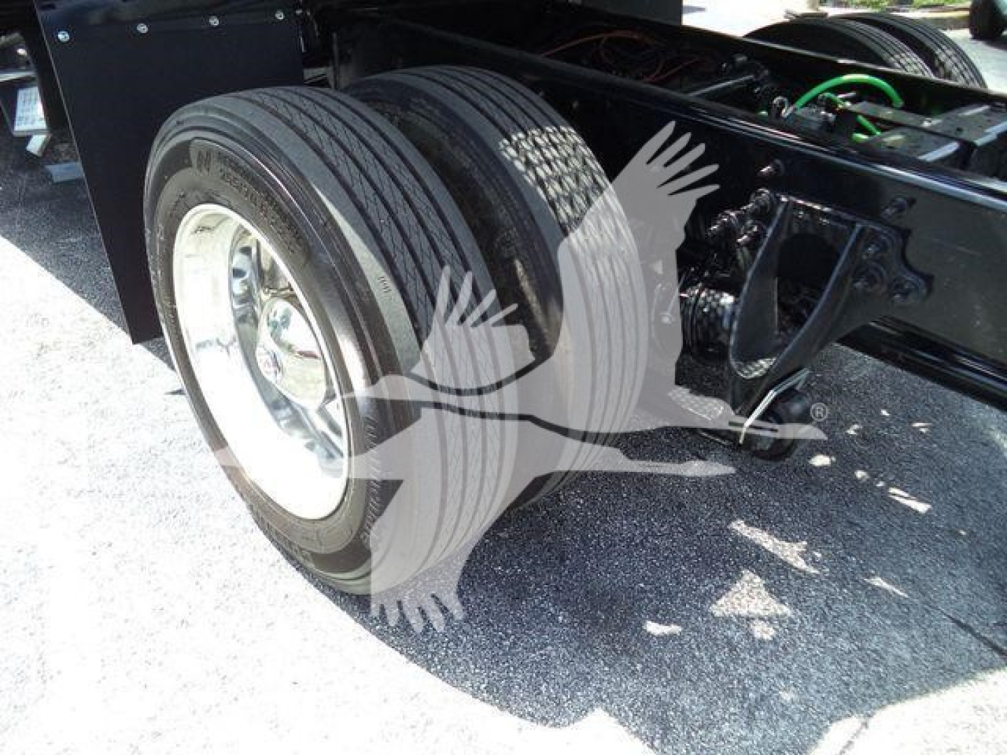 International MV truck dual rear axles with large tires and wheel rims in view, chassis frame and suspension components visible in the background.
