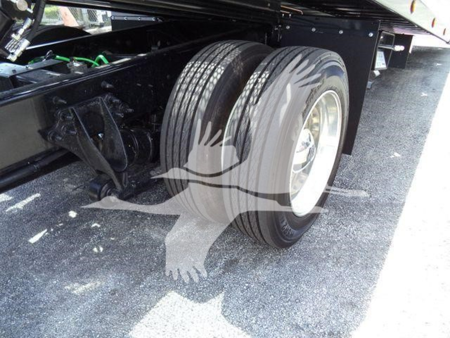 Truck chassis side view showing dual rear tires and suspension underframe of a 2027 International MV rollback tow truck.