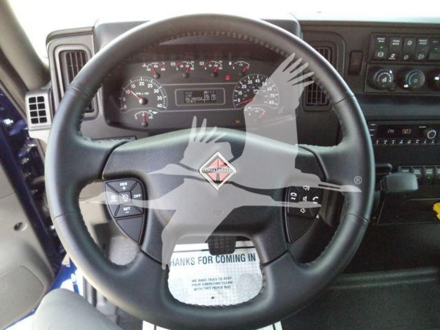 Steering wheel and dashboard of a new 2027 International MV truck showing instrument cluster and controls.