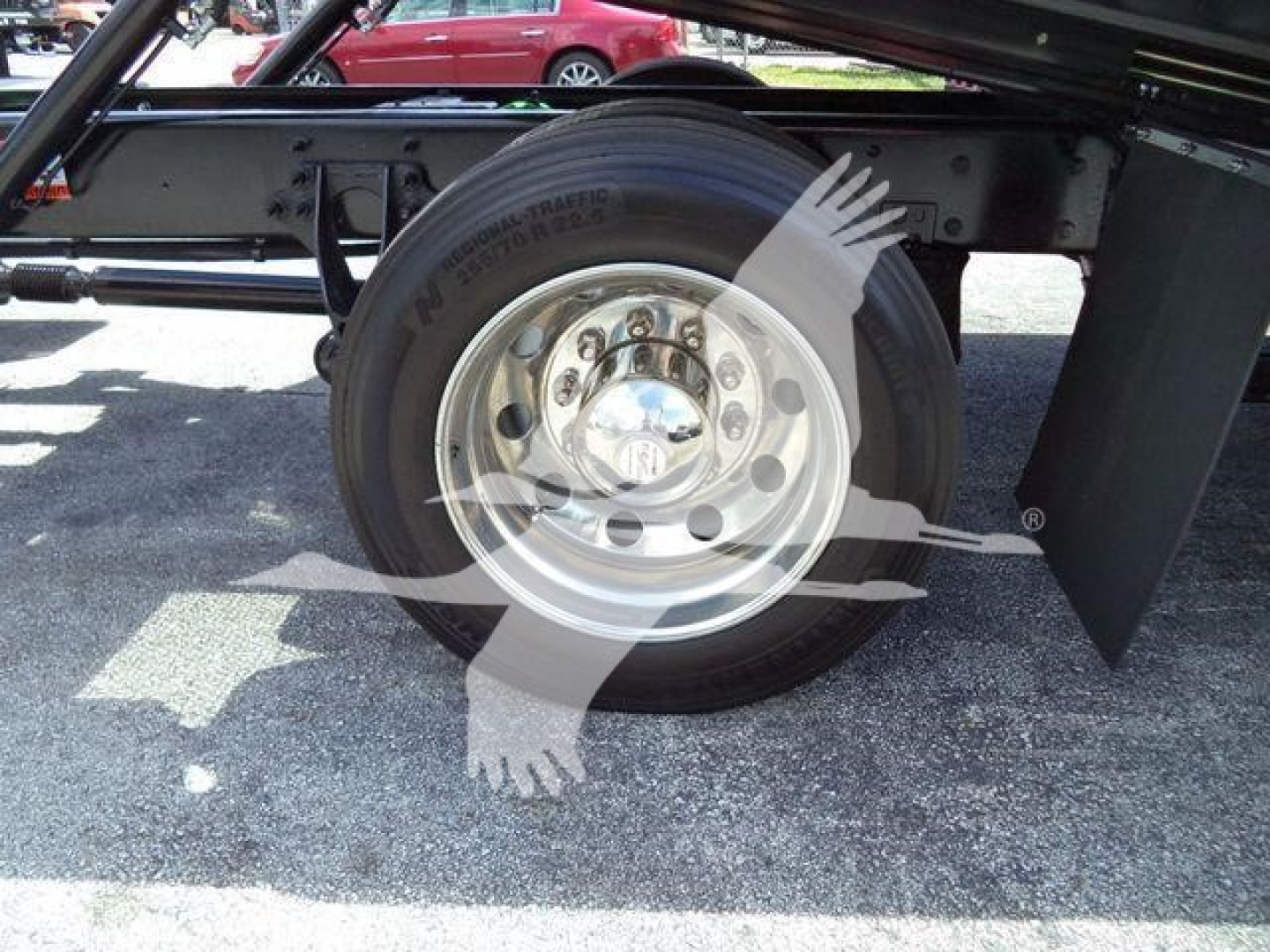 Wheel and tire view of a new International MV truck chassis showing a single rear/side wheel with steel rim and black fender assembly.