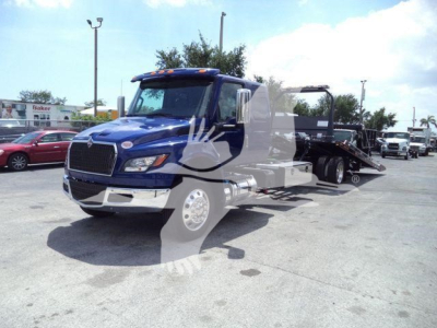 Blue 2027 International MV rollback truck with flatbed tow body and loading ramps, front grille and large side mirrors visible.