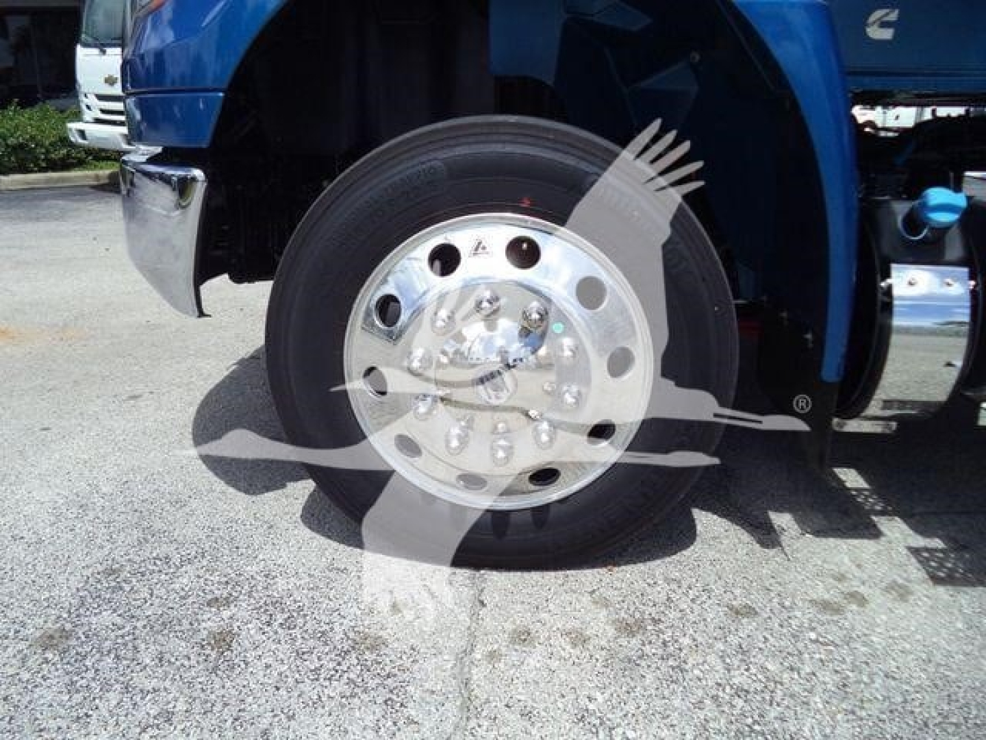 Wheel with chrome hubcap on a blue International MV truck showing front wheel.