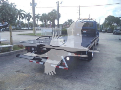 Truck bed of a 2027 International MV rollback truck shown from rear-left view with flatbed and rear lighting.