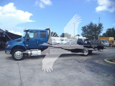 International MV rollback truck side view showing blue cab and long flatbed.