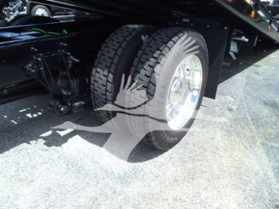 Truck wheel and suspension view showing rear dual wheels and part of undercarriage on a new 2027 International MV rollback truck.