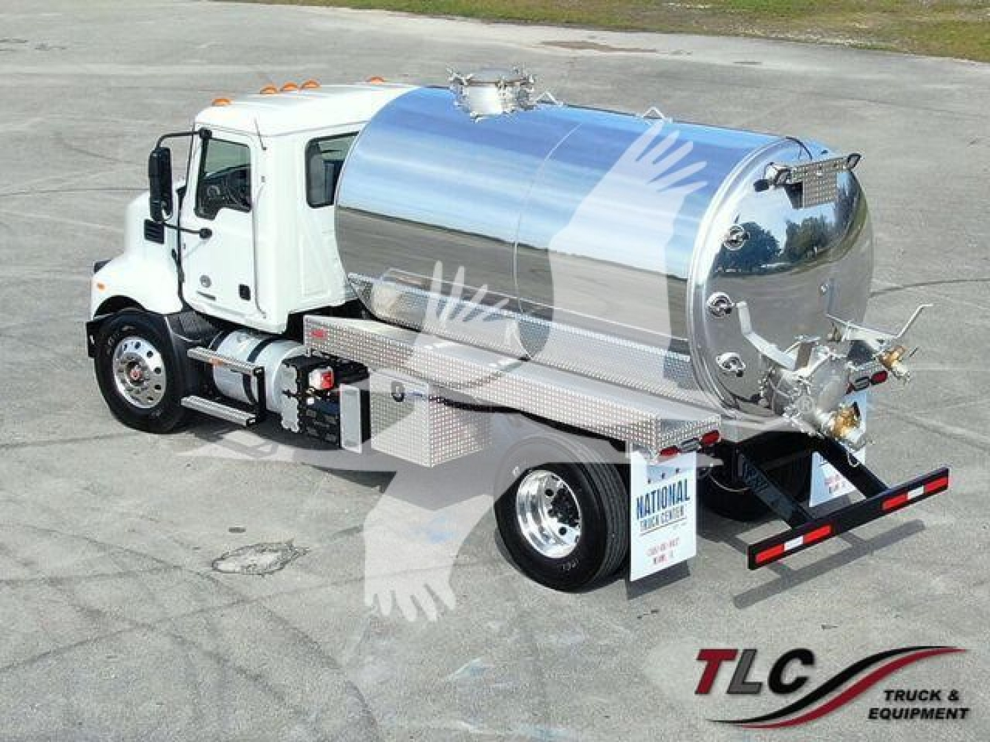 Truck-mounted sewer/vac tanker on a white Mack MD7 tractor showing polished stainless steel tank and rear plumbing access panels.