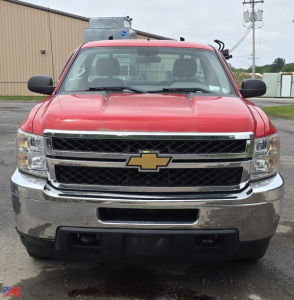 Front view of a red 2012 Chevrolet Silverado 2500HD pickup truck showing grille with gold Chevrolet bowtie logo, chrome bumper, and black lower grille.