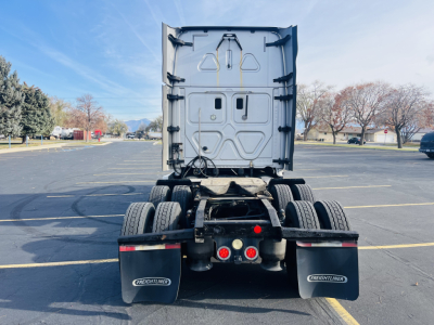 Truck rear view shows Freightliner Cascadia 125 conv sleeper, dual rear axles, mud flaps, and rear bumper with lights.