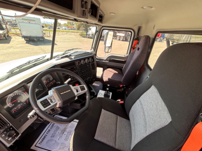 Mack GR64B truck interior showing driver's seat and steering wheel with Dash controls and gauges visible.