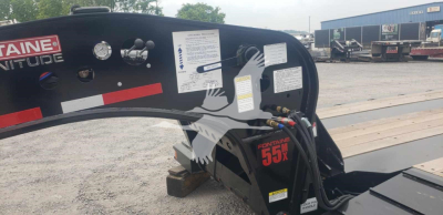 Trailer hitch end showing Fontaine Magnitude 55MX logo and control panels on black steel beam with labels and warning stickers.