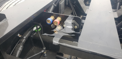 Trailer hydraulic system valves and hydraulic pump with Philips component in engine bay area of Fontaine Magnitude 55Mx lowboy trailer.
