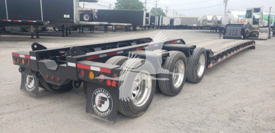 Lowboy trailer showing tandem axles and rear lights with Fontaine logo mud flaps and metallic frame.