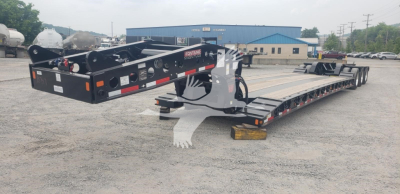 Trailer chassis and lowboy deck showing Fontaine Magnitude 55Mx trailer with black frame and multiple axles, side rails, and front gooseneck in view.