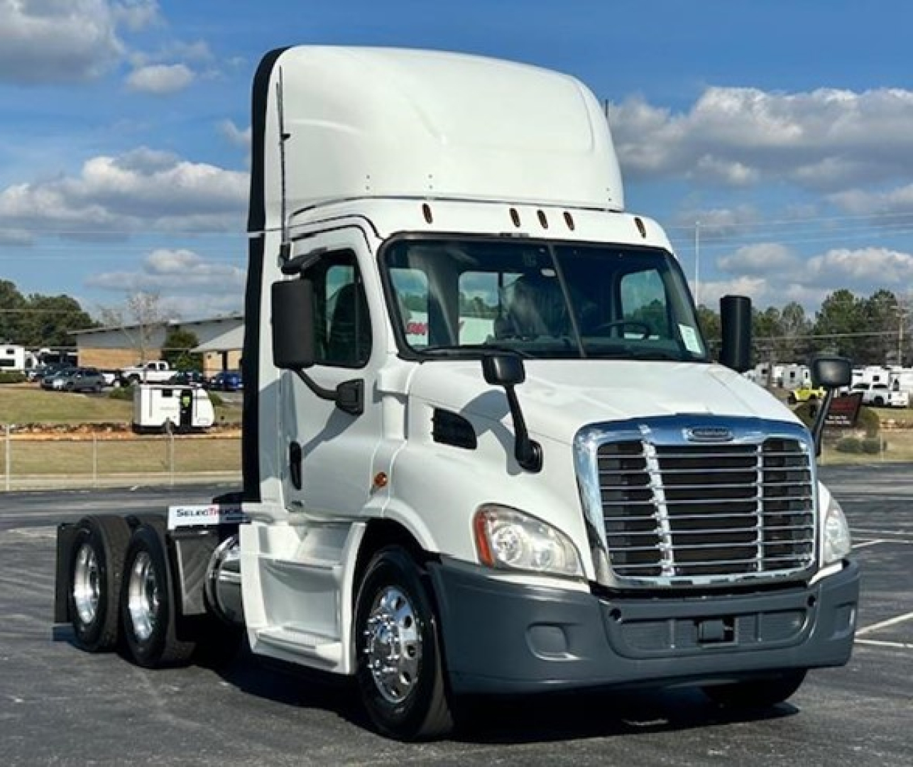 Truck cab showing Freightliner Evolution 113 day cab chassis with chrome grille and white body.