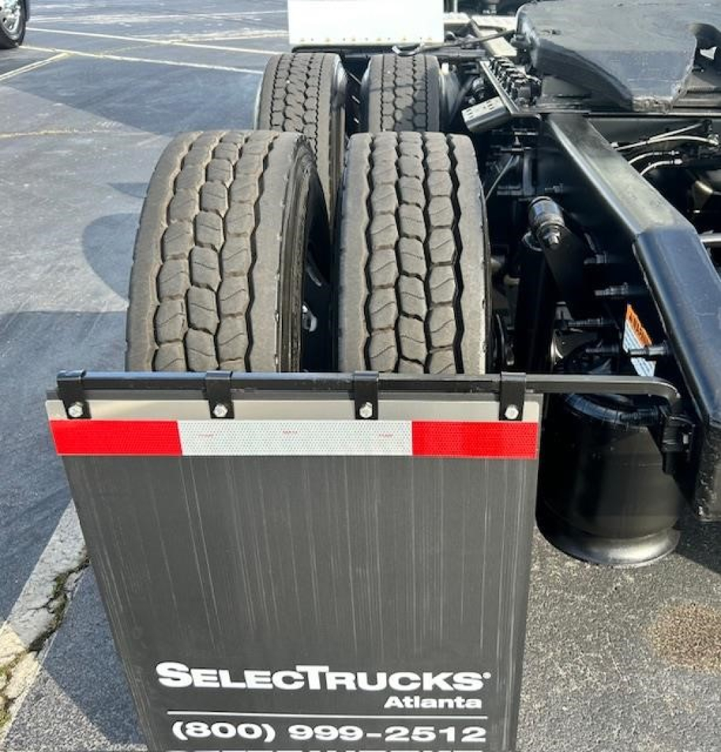 Rear view of a Freightliner Cascadia 113 Evolution truck showing dual rear axles, tires, and a black mudflap with SelectTrucks Atlanta branding.