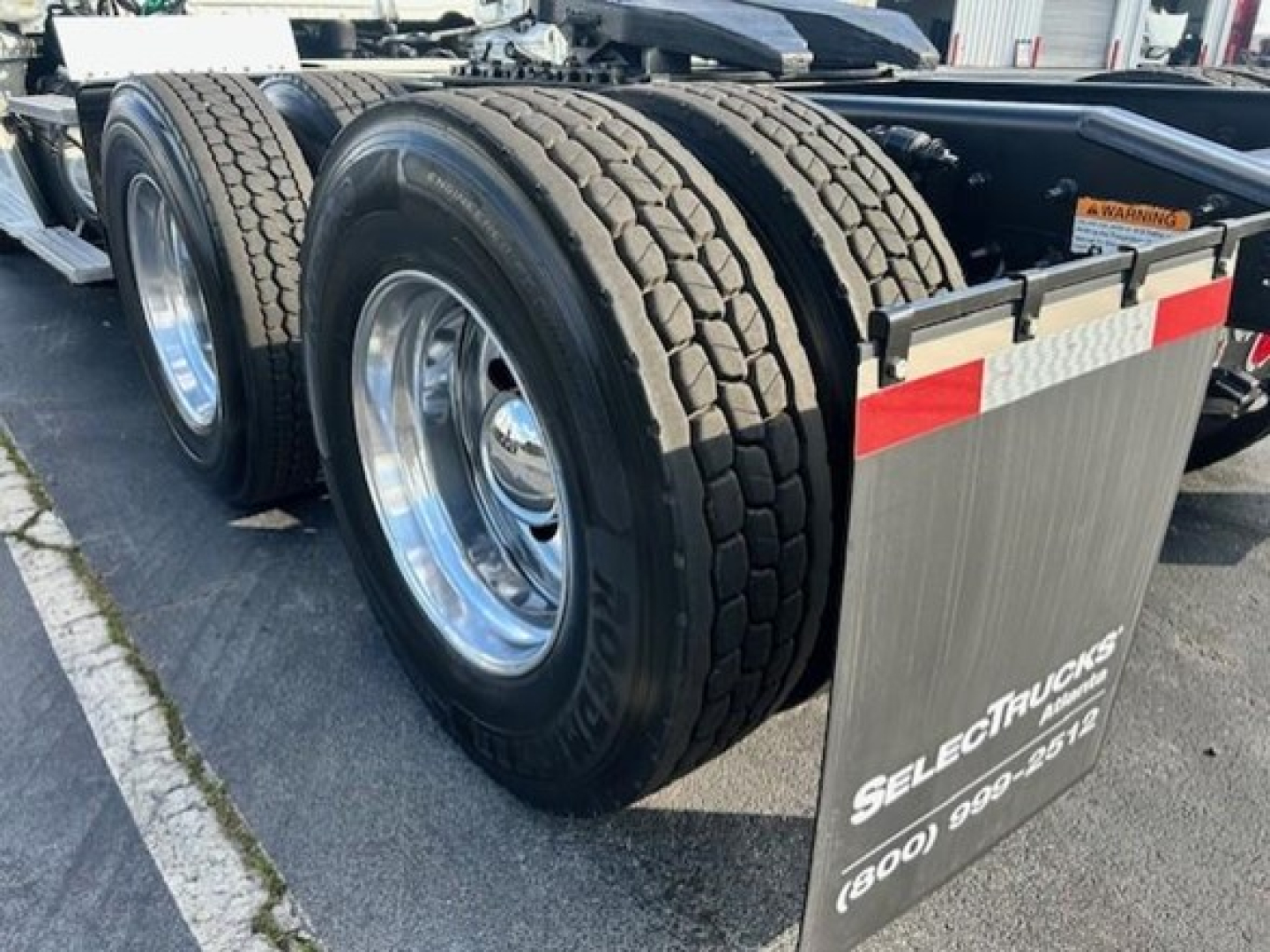 Freightliner Cascadia 113 Evolution rear dual tires and mud flaps with reflector strip.