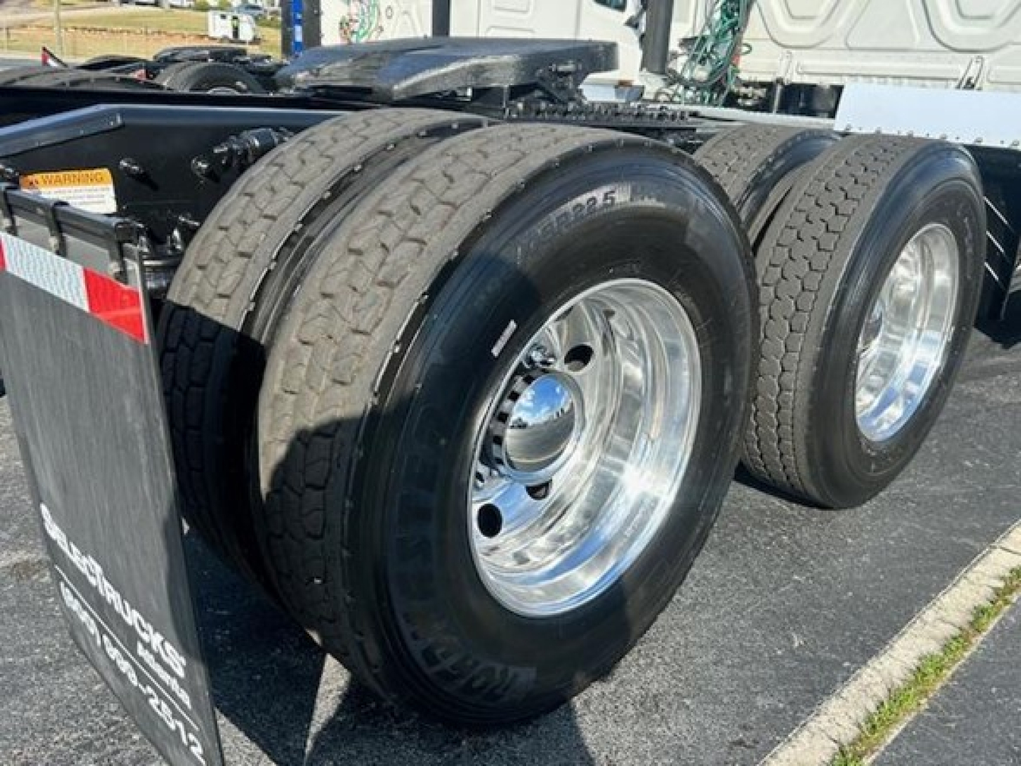 Dual rear truck tires on a Freightliner Cascadia Evolution 113 chassis showing polished rims and tread wear.