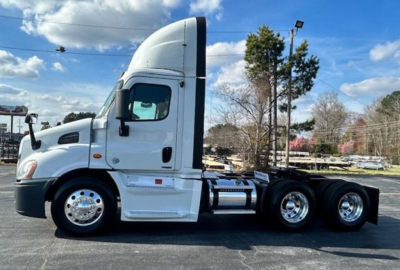Tractor unit side view showing Freightliner Cascadia Evolution 113 with sleeper cab and chrome fuel tanks.