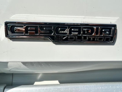 Freightliner Cascadia Evolution badge on white truck showing CASCADIA EVOLUTION text.