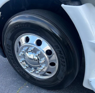 Wheel close-up of a Freightliner Cascadia Evolution 2016 showing a polished chrome hubcap with multiple lug nuts and a Dunlop tire sidewall.