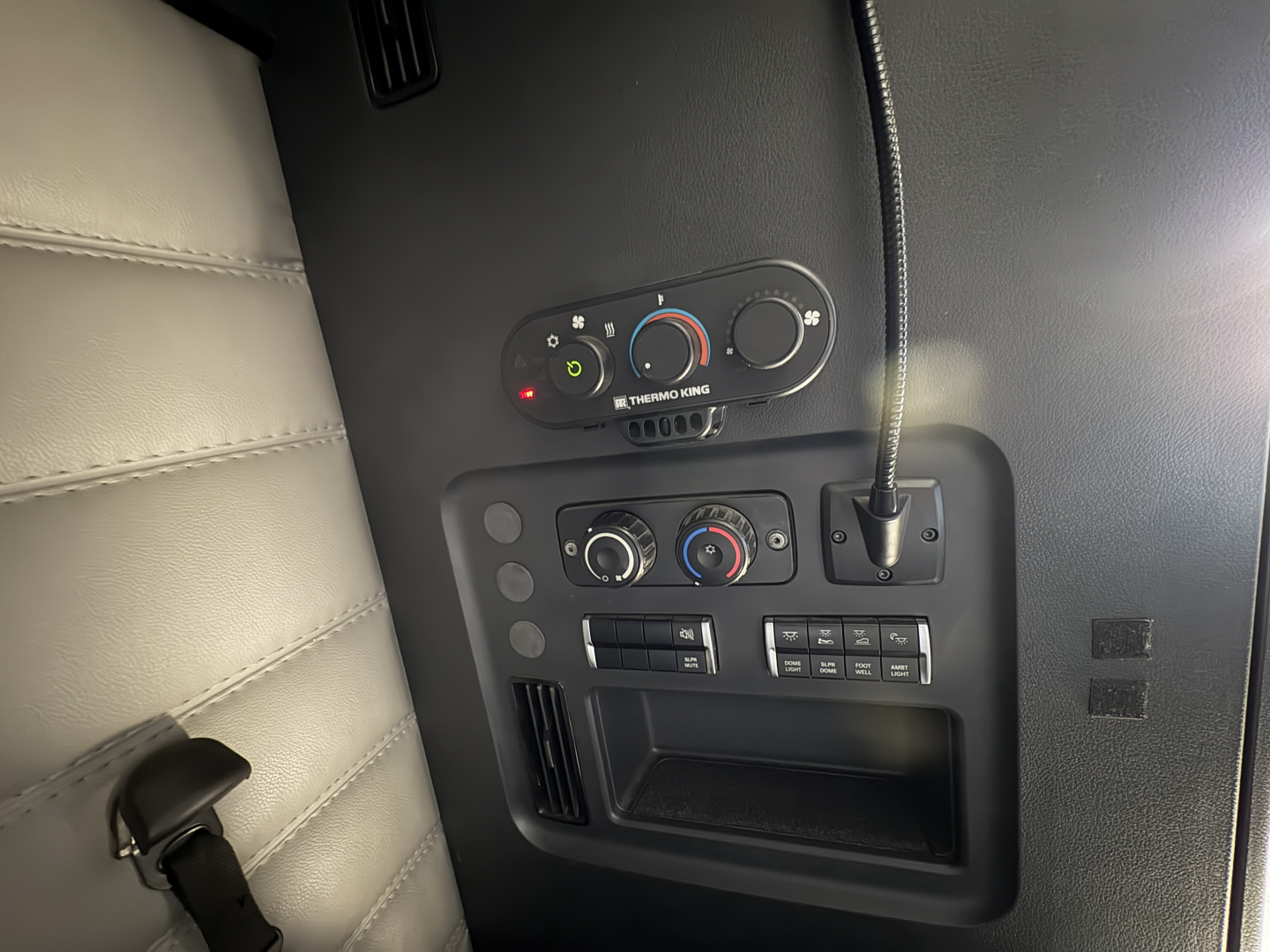 Freightliner Cascadia 126 dash controls and HVAC panel in view; knobs and ports visible with circular gauges and indicator lights.