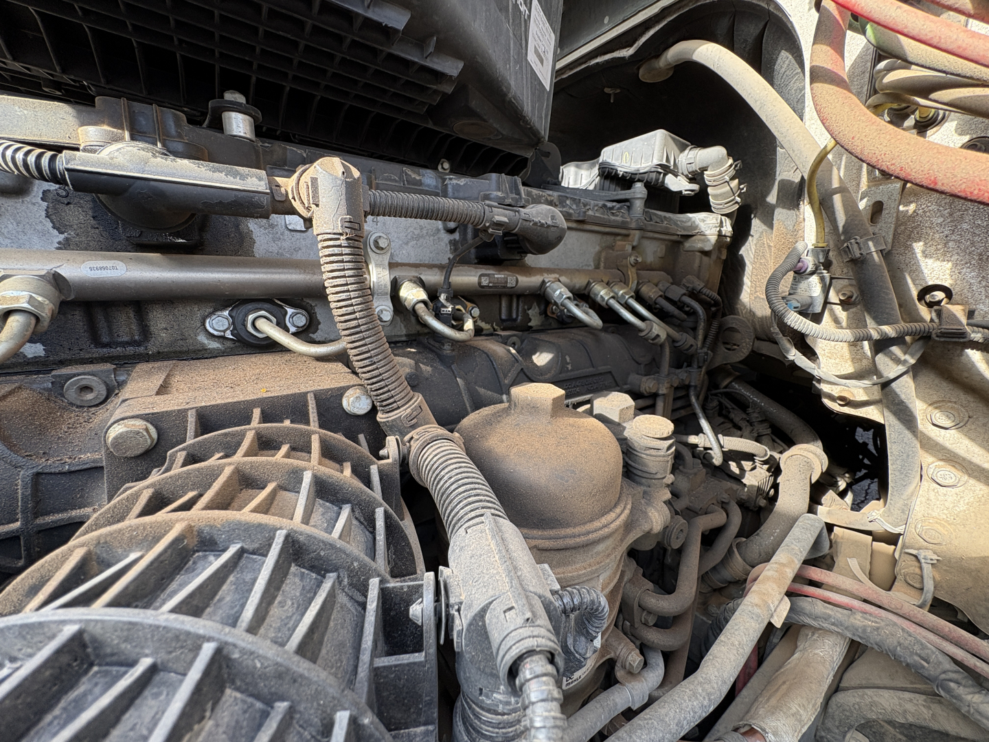 Engine bay of a Freightliner Cascadia 126 showing hoses, wiring, and turbocharger area in view.