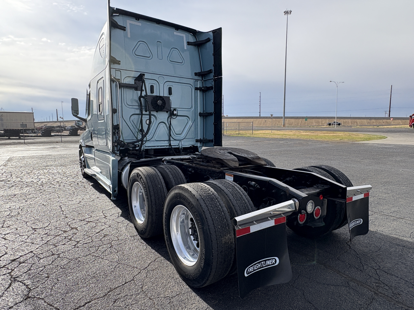 Freightliner Cascadia 126 tractor rear view showing dual rear axles, fifth-wheel area, and mudflaps with Freightliner logo.