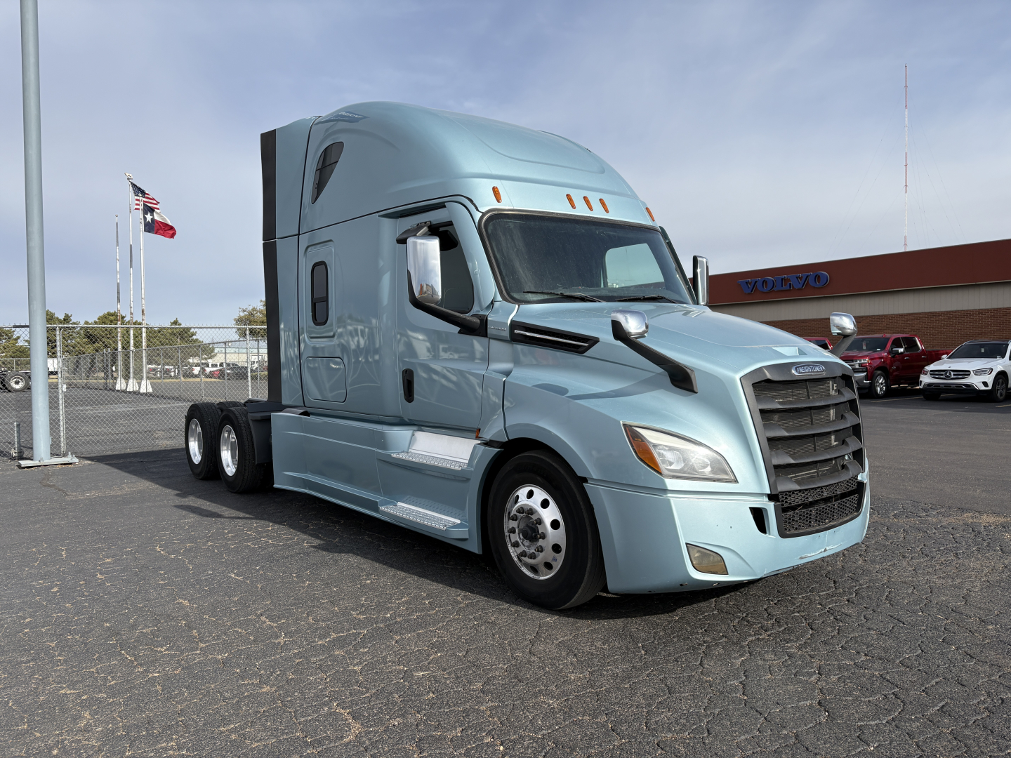 2023 Freightliner Cascadia 126 semi-truck in a light blue color, front three-quarter view, with large black grille and sleeper cab.