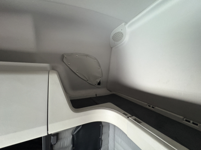 Freightliner Cascadia 126 sleeper cab interior corner showing storage compartments and speaker grill.