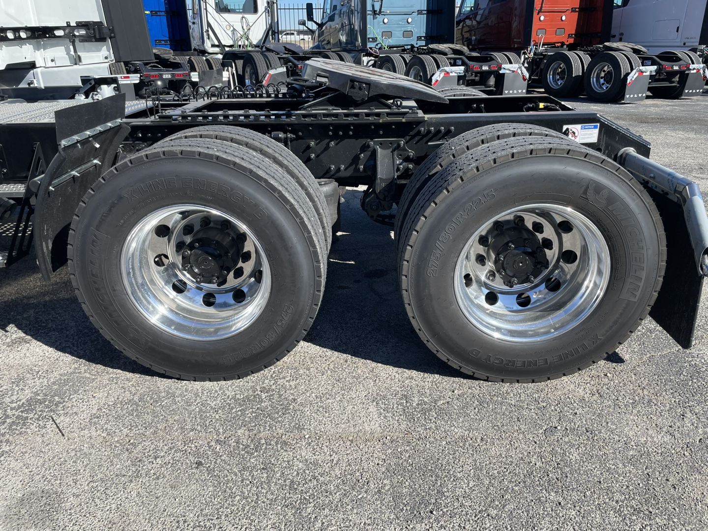 Volvo VNL64T860 chassis showing dual rear axles with polished chrome wheels and tires.