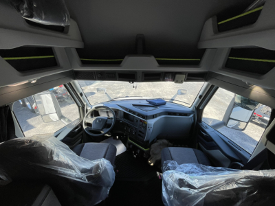 Truck cab interior dashboard and steering wheel of a Volvo VNL truck.
