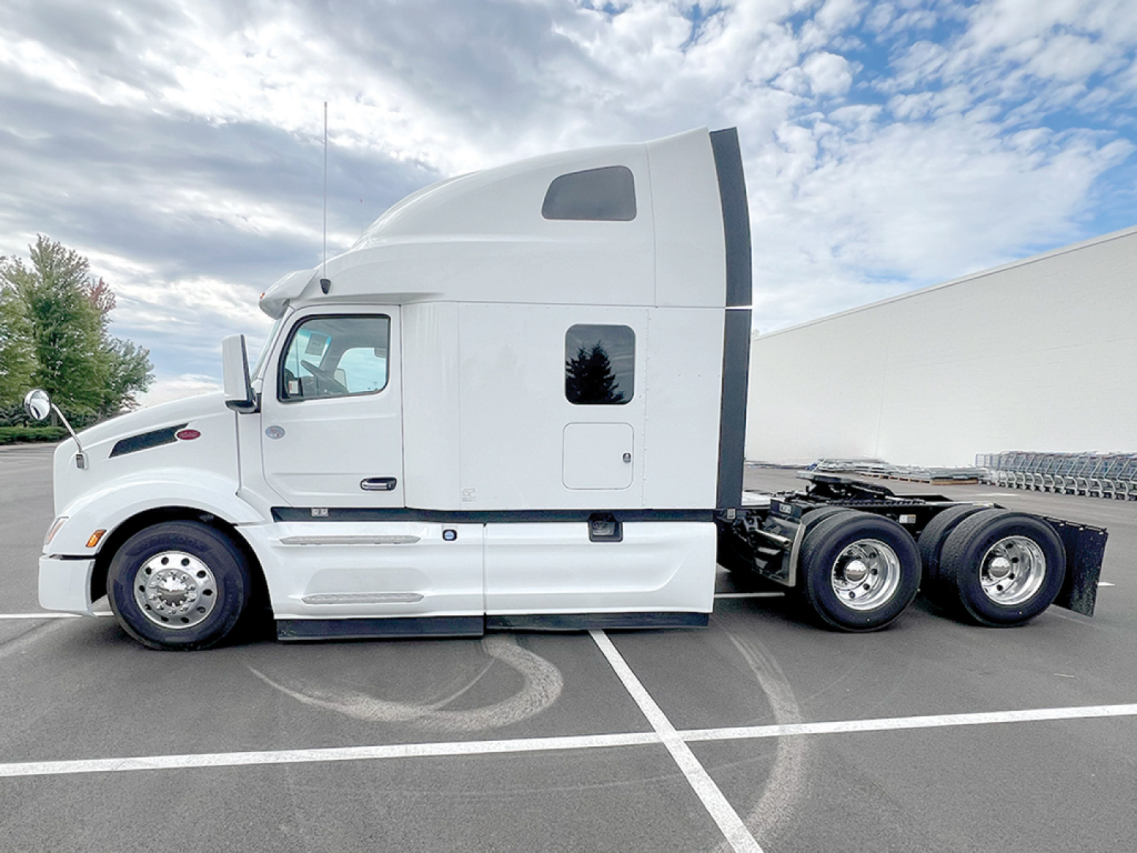 Peterbilt 579 semi-truck in side profile view showing sleeper cab and rear wheels.