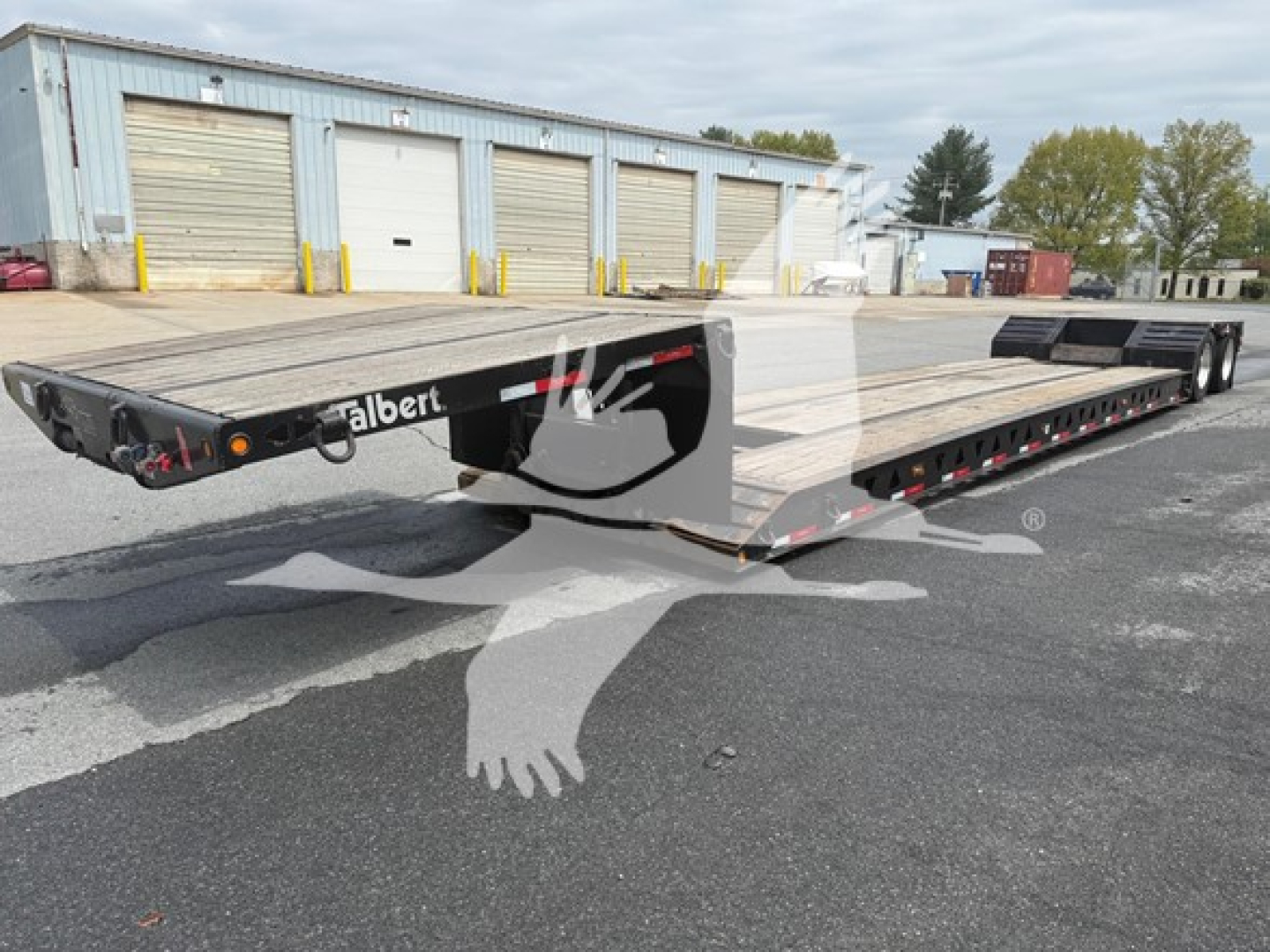 Talbert mechanical detach lowboy trailer showing wood deck and dual-sided ramps with Talbert branding visible.