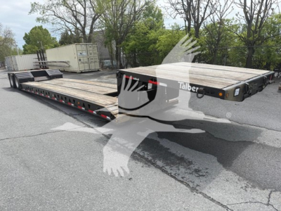 Talbert lowboy trailer with wooden deck and steel frame, 2022 model, on lot; branding shows Talbert on side; flatbed with ramps and wheel chocks; VIN 40FS04822N5040979 visible in listing details.