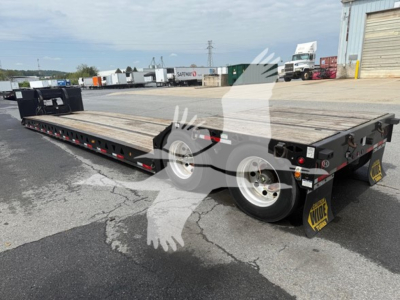 Lowboy trailer with wooden deck showing Talbert mechanical detachable gooseneck components and dual axles with black fenders and yellow KYOTO-style wheel chocks.
