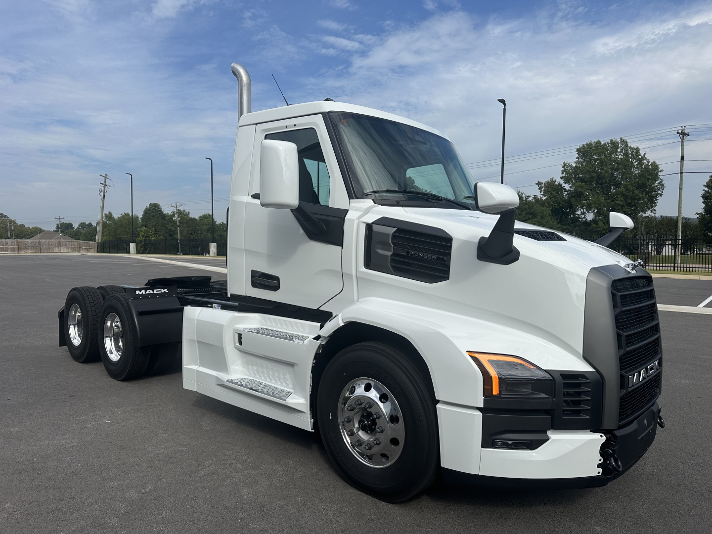 Mack PR64T conventional daycab truck in white, side view, showing cab, dual rear axles, exhaust stack, and chrome wheels.