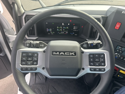 Steering wheel and dashboard of a 2026 Mack PR64T, with digital instrument cluster and control buttons on the steering wheel showing Mack branding.