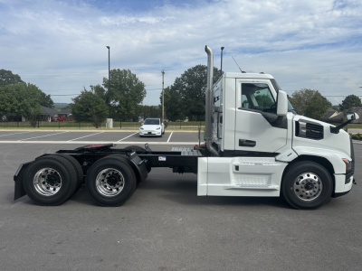 Mack PR64T conventional daycab truck side view showing chassis and three axles with white cab and black frame