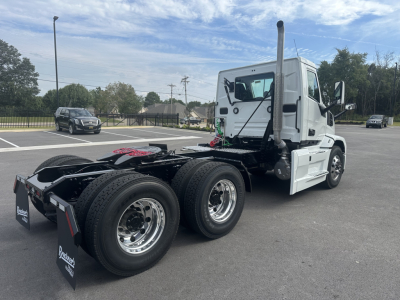 Mack PR64T truck tractor in white, side rear view showing dual rear axles and fifth wheel area.